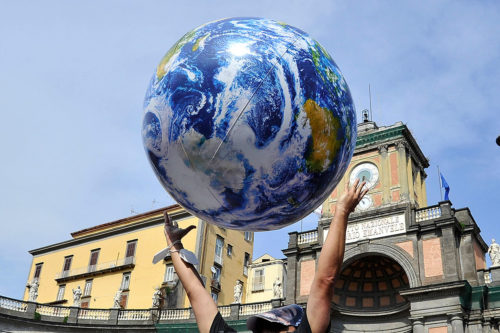 Un manifestant lance dans les airs un ballon représentant la planète Terre lors de la manifestation contre l'environnement du G20 qui s'est tenue à Naples, en 2021. Crédit Vincenzo Izzo/Sipa USA/SIPA