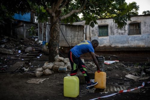 Un habitant remplit des bidons d'eau potable à Koungou sur l'île de Mayotte