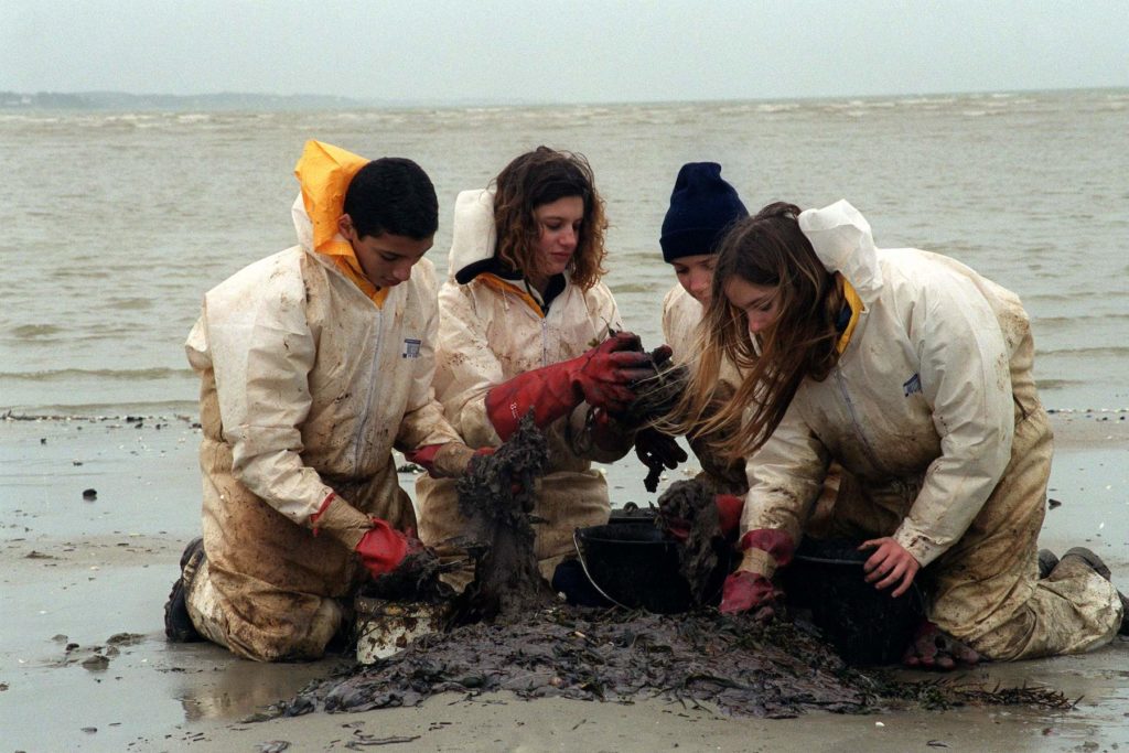 Des jeunes bénévoles nettoient la plage de Pont-Mahe en Bretagne après la marée noire de l’Erika en 2003
