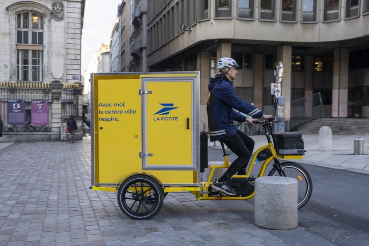 Un facteur de La Poste conduisant un vélo cargo électrique à Lyon